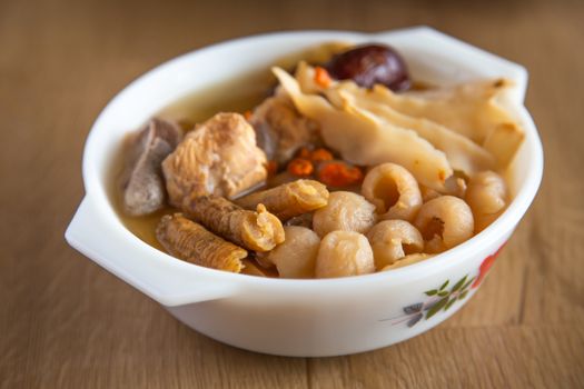 chinese herbal soup on wooden bachground