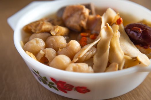 chinese herbal soup on wooden bachground
