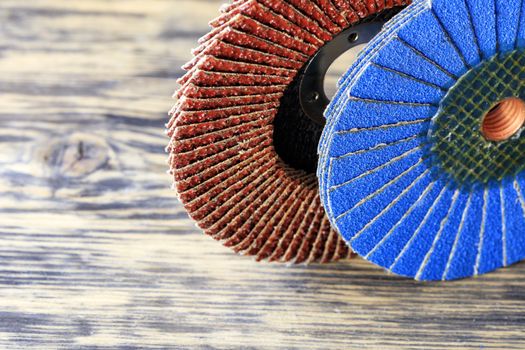 Grinding discs of various grains for grinding wood and rusty metal together on a light beige background in unsharpness, close-up.