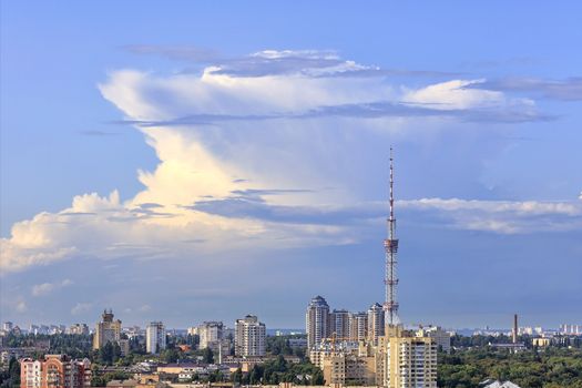 Cityscape of summer at noon with a television tower against the magical clouds of blue sky.