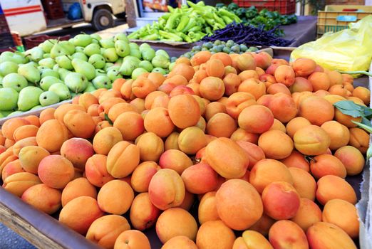 Bright background of fresh fruits, apricots, pears, plums lie in trays in the market and attract attention.