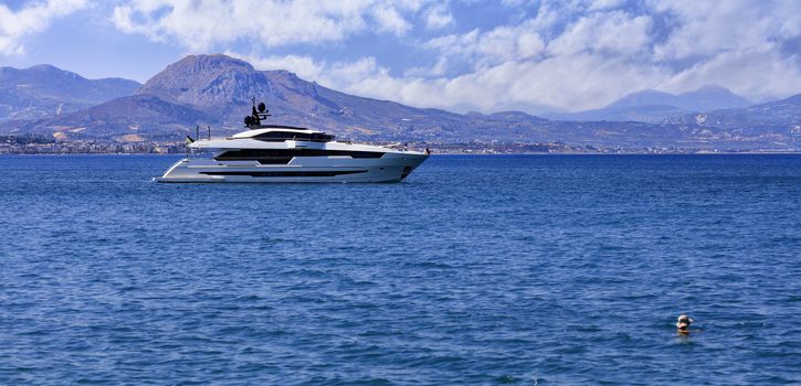 Silhouette of a sea yacht against the backdrop of Mount Acropolis and the city of Corinth in Greece in the morning haze.