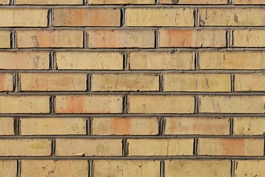 The old brick wall have an orange color and a weathered texture with cement jointing.