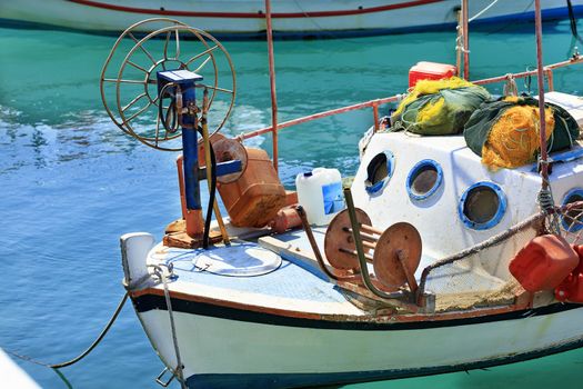 A fishing boat with fishing nets is anchored in the clear waters of the Ionian Sea. Loutraki, Corinth, Greece.