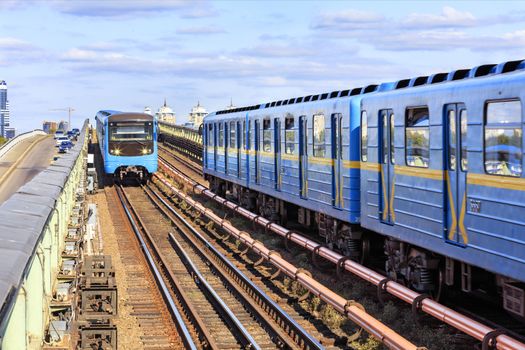 The railway line from the metro bridge in Kyiv, along which two trains of metro rush towards each other.