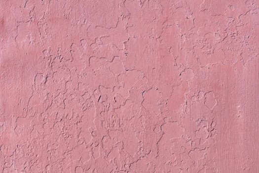 The old wall is repeatedly painted with red paint on top peeled off of the shabby old texture of previous paints.