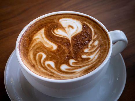 Coffee cup latte art on wood table