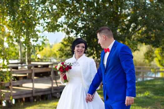 The bride and groom on a wedding walk. The bride and groom with a bouquet