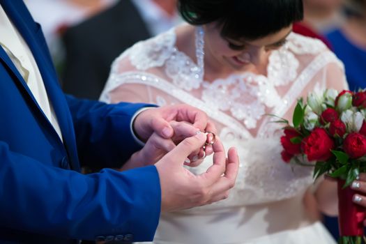 The groom dresses the bride's engagement ring.To put on an engagement ring