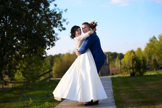 Happy bride and groom on a walk in nature. The bride and groom on a walk