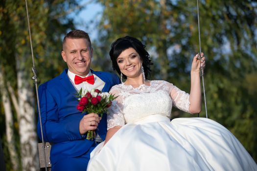 The bride and groom on the swing.The bride and groom on a walk