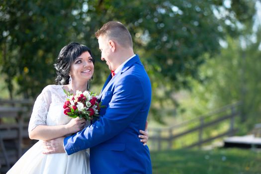 The bride and groom on a wedding walk. The bride and groom with a bouquet