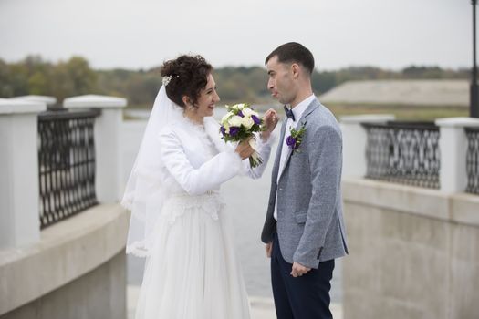 The bride and groom on a wedding walk in nature.The groom showed the bride a tongue