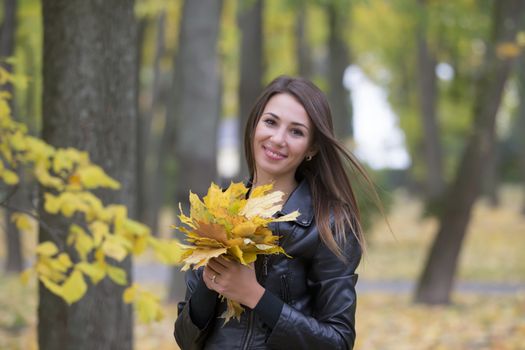 Girl with a bouquet of autumn leaves