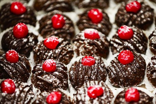 Small chocolate cakes with red cream. Chocolate cakes