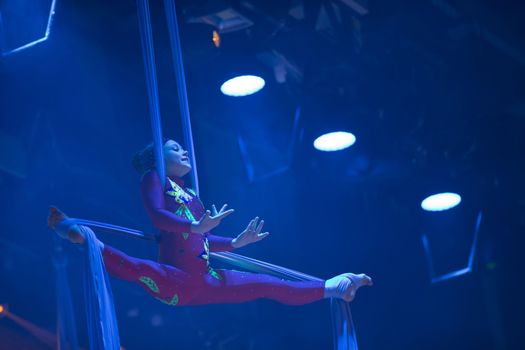 A girl dancing a dance on canvases.Children's sports. Girl gymnast. Straight tricks