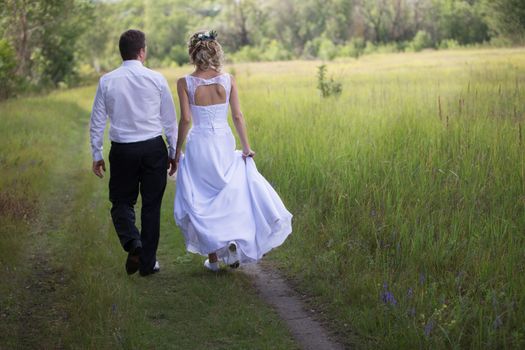 Bride and groom walking along the forest road.Wedding day. The bride before the wedding. Love of man and woman. Lovely couple. Bride and groom.