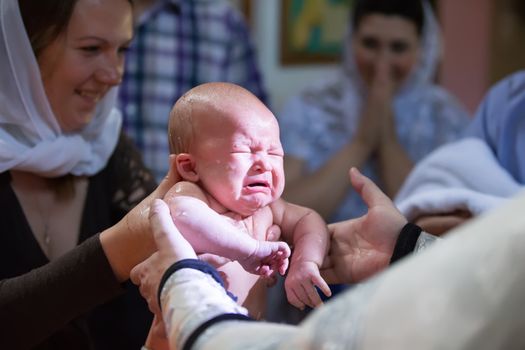Belarus, the city of Gomel, St. Nicholas Monastery.July 23, 2017.Baptism of the Child.The infant is washed on the rite of baptism.Baptism of the baby. Accept the faith. Newborn in the church.