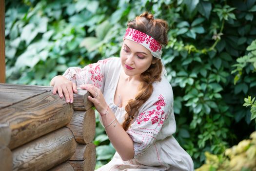 Russia, Moscow, August 27, 2017, the international festival of photography.Russian girl in national dress at a wooden well