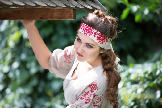 Russia, Moscow, August 27, 2017, the international festival of photography.Russian girl in national dress at a wooden well