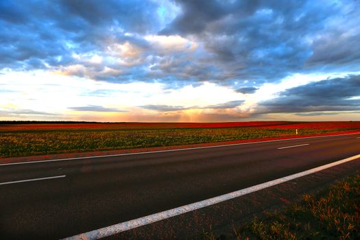 Outgoing road at sunset.Landscape from the outgoing road, fields and sky