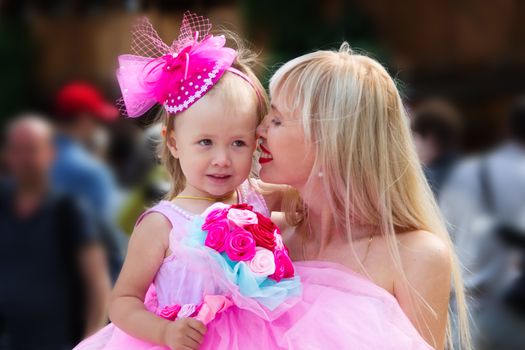 Mom kisses her little daughter