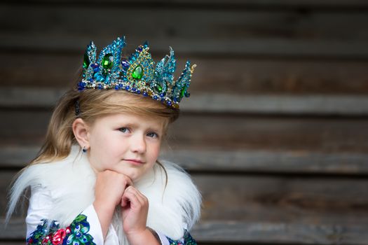 Russia, Moscow, Izmaylovsky Park, August 27, 2017. International Photo Festival.A sad little queen. Girl with a crown scarecrow