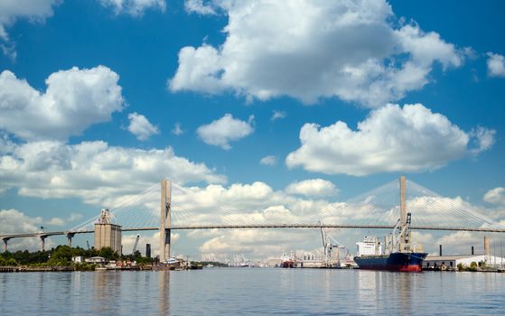 Freight industry at busy harbor on the Savannah River with suspension bridge