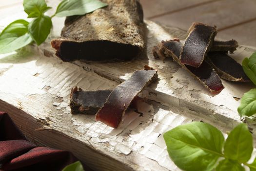 dried roe deer meat on a rustic cutting board