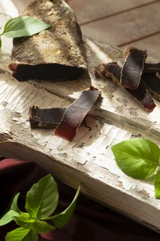 jerked meat, wild deer dry meat on a rustic table, vertical image