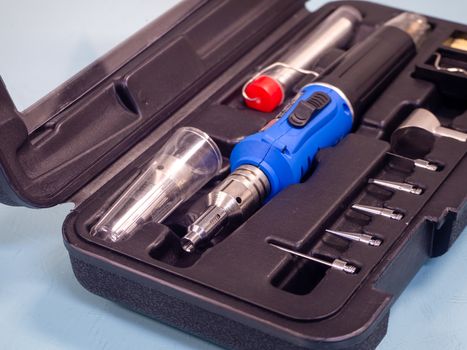 Gas soldering iron in black box isolated on white background.