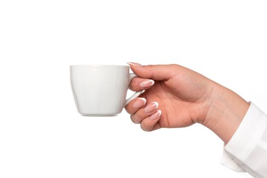 Beautiful and perfect female hand holding a white porcelain cup isolated on a white background in close-up