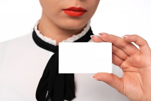 Young business woman with perfect fingernails holds blank business card in close-up.