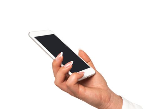 Female hand with perfect fingernails holding smartphone with blank screen on a white background in close-up.