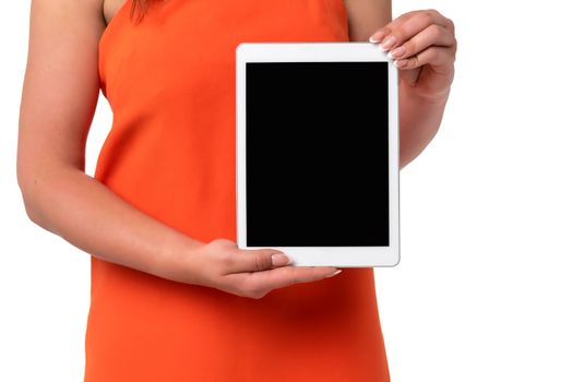 Technology advertising concept image - woman in orange dress with perfect fingernails holding digital tablet with blank screen.