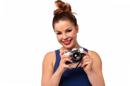 Amateur photographer concept - beautiful and attractive woman holding a retro SLR camera and smiling isolated on a white background.