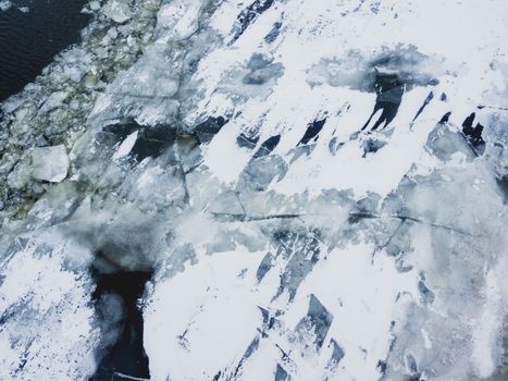 Broken ice on a frozen river. Water with shards of ice.
