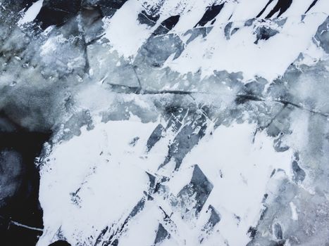 Broken ice on a frozen river. Water with shards of ice.