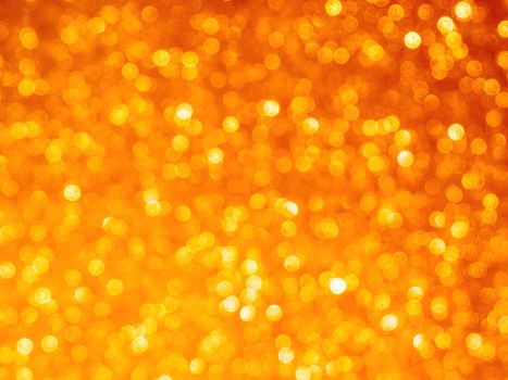 Defocused light reflections of golden sparkling fabric. Blurred colorful bokeh background.