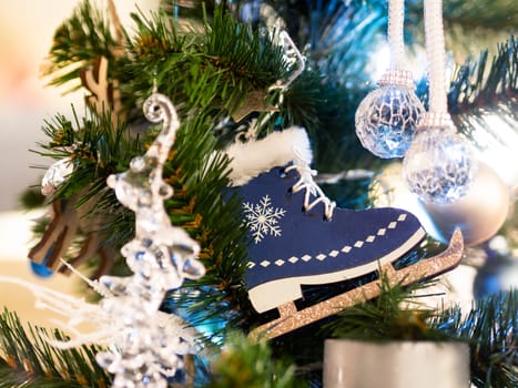Christmas and New Year rustic decorations - wooden skates and glass balls on Christmas tree with light bulbs.