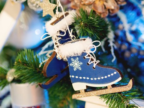 Christmas and New Year rustic decorations - wooden skates and glass balls on Christmas tree with light bulbs.