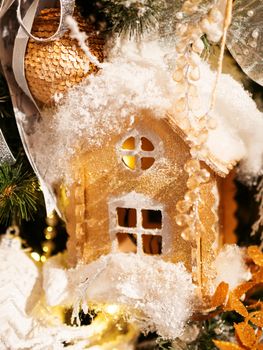 Golden hand made house made of cardboard. Bright shiny New Year decoration for Christmas tree.
