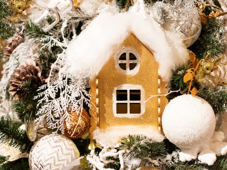 Golden hand made house made of cardboard. Bright shiny New Year decoration for Christmas tree.