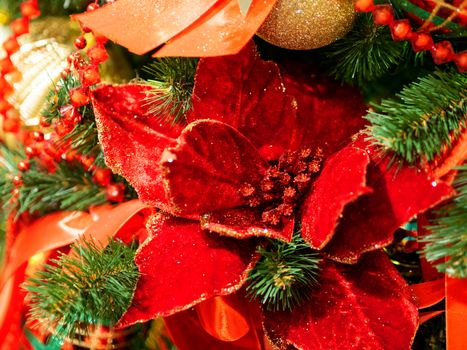 Elegant red flower, made of fabric with sequins. New Year decoration for Christmas tree.