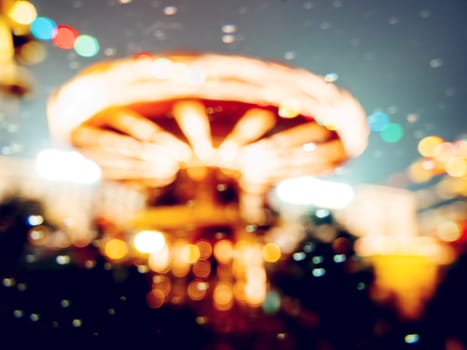 Blurred background with Red Square decorated for New Year and Christmas fair. Colorful carousel decorated with light bulbs. Moscow, Russia.