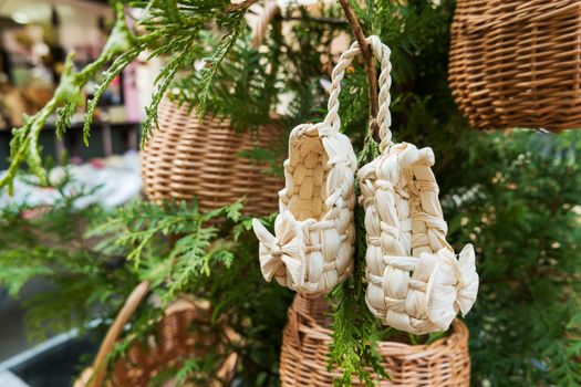 Sandals made of straw, ancient traditional russian type of footwear. Natural sandals for baby with a bow.