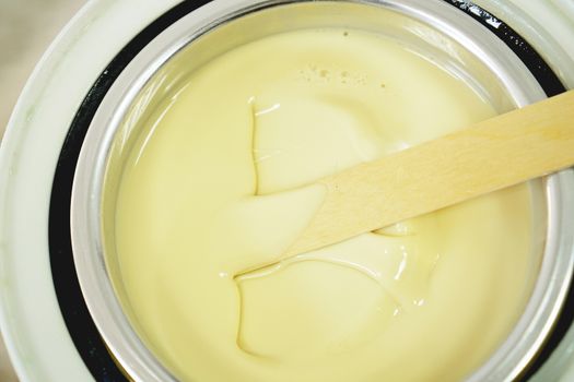 Preparation of wax for shugaring. Close-up wax for depilation is heated and melted in a round container