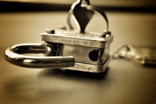 conceptual macro image of unlocked lock with attached key with key ring