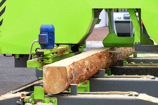 Woodworking, lumber, pine boards are made from large logs in a modern automatic sawmill.