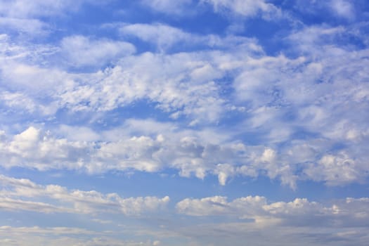 Blue sky background with the texture of white and fluffy clouds.